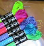 Skeins of flourescent yellow, purple, pink, blue and green embroidery threads