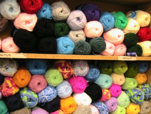 two shelves of balls of yarn in different colours