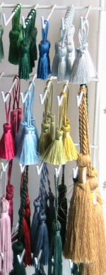 a rack of green, blue, white, gold, maroon, pink tassles
